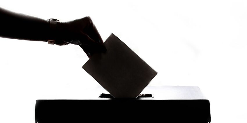 hand dropping ballot in box