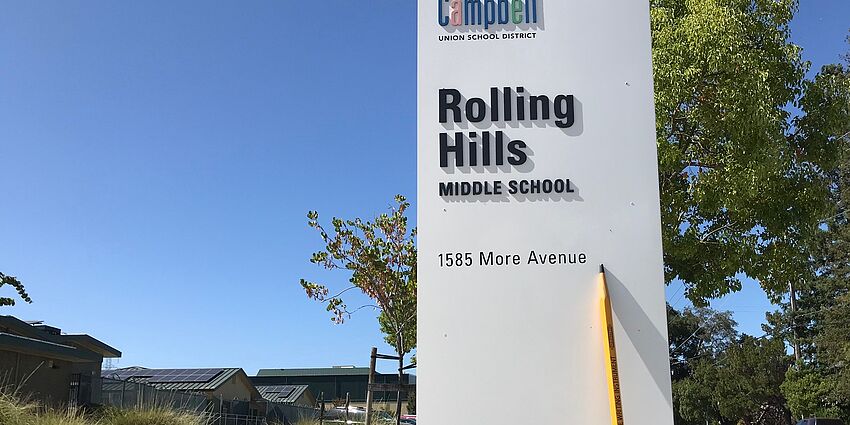 pencil leaning against rolling hills sign