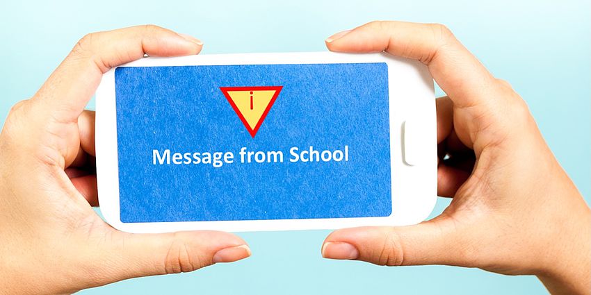 hands holding cell phone with message from school