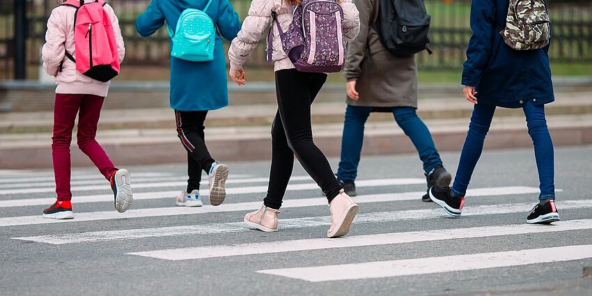 legs of students walking in a crosswa;l