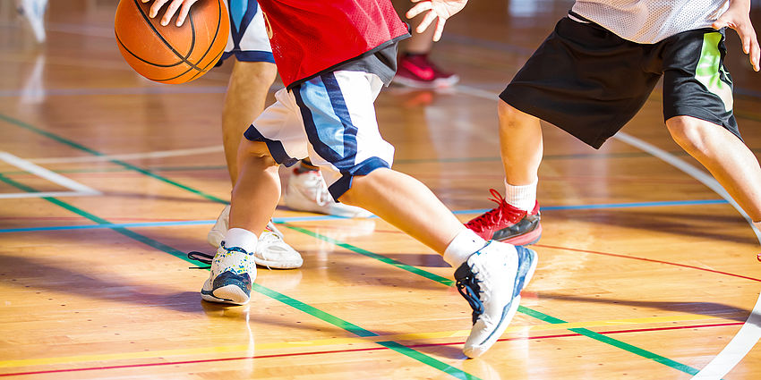 legs of boys playing basketball