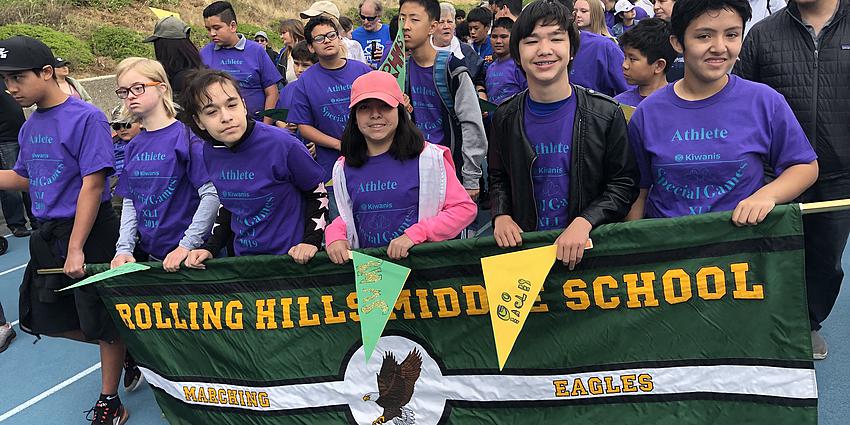 students hold banner at special games parade
