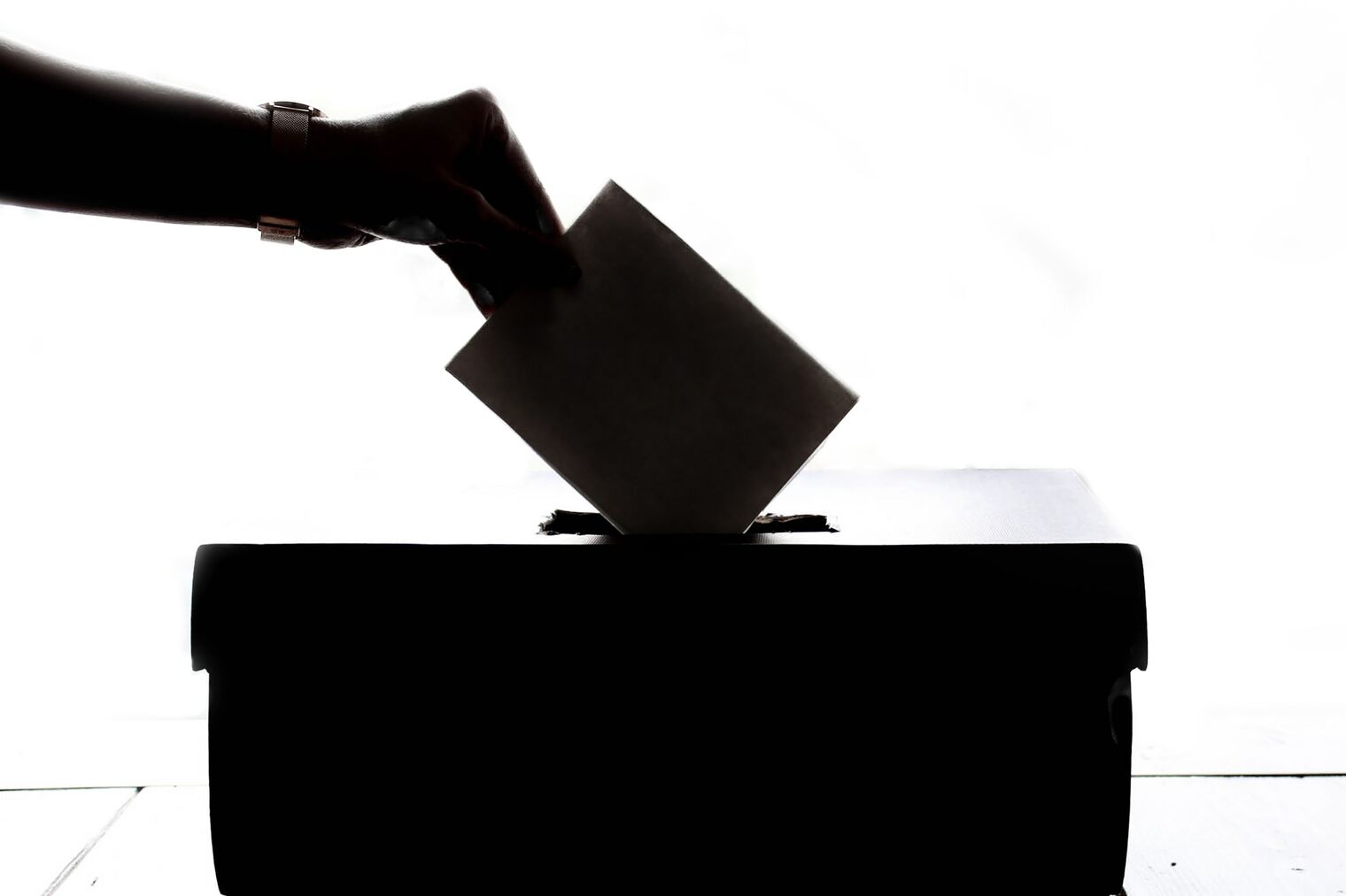 hand dropping ballot in box