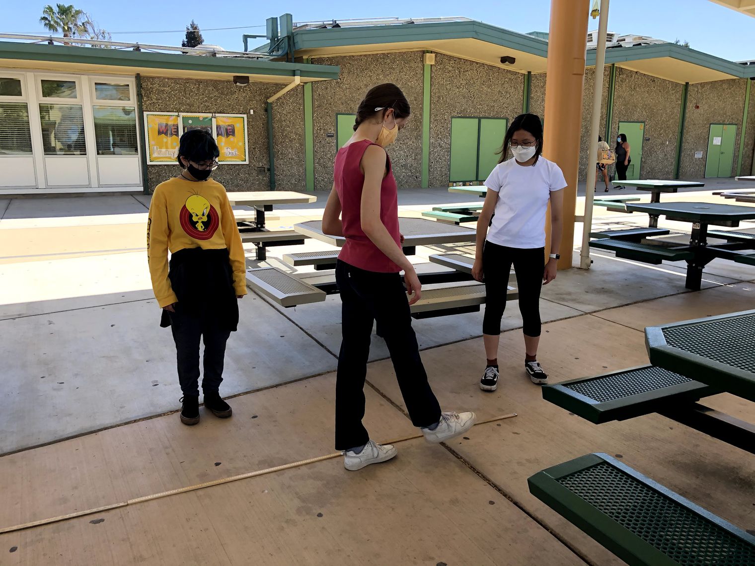 three students work outside on project
