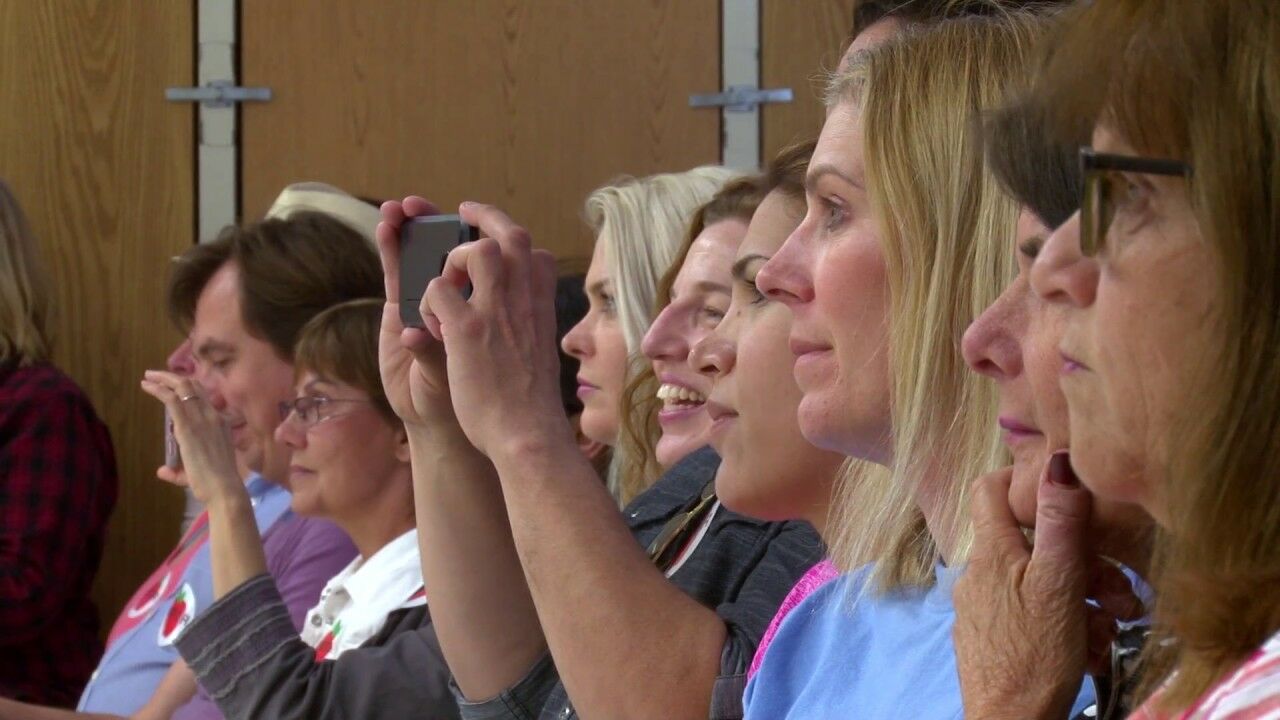 parents taking photos of students performing in school choir