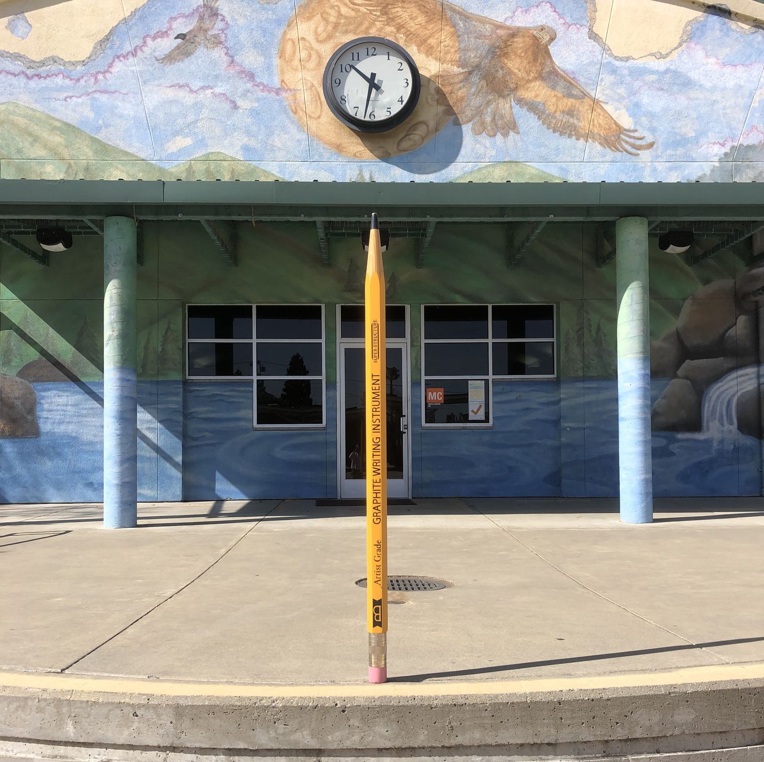 extra large pencil in front of library