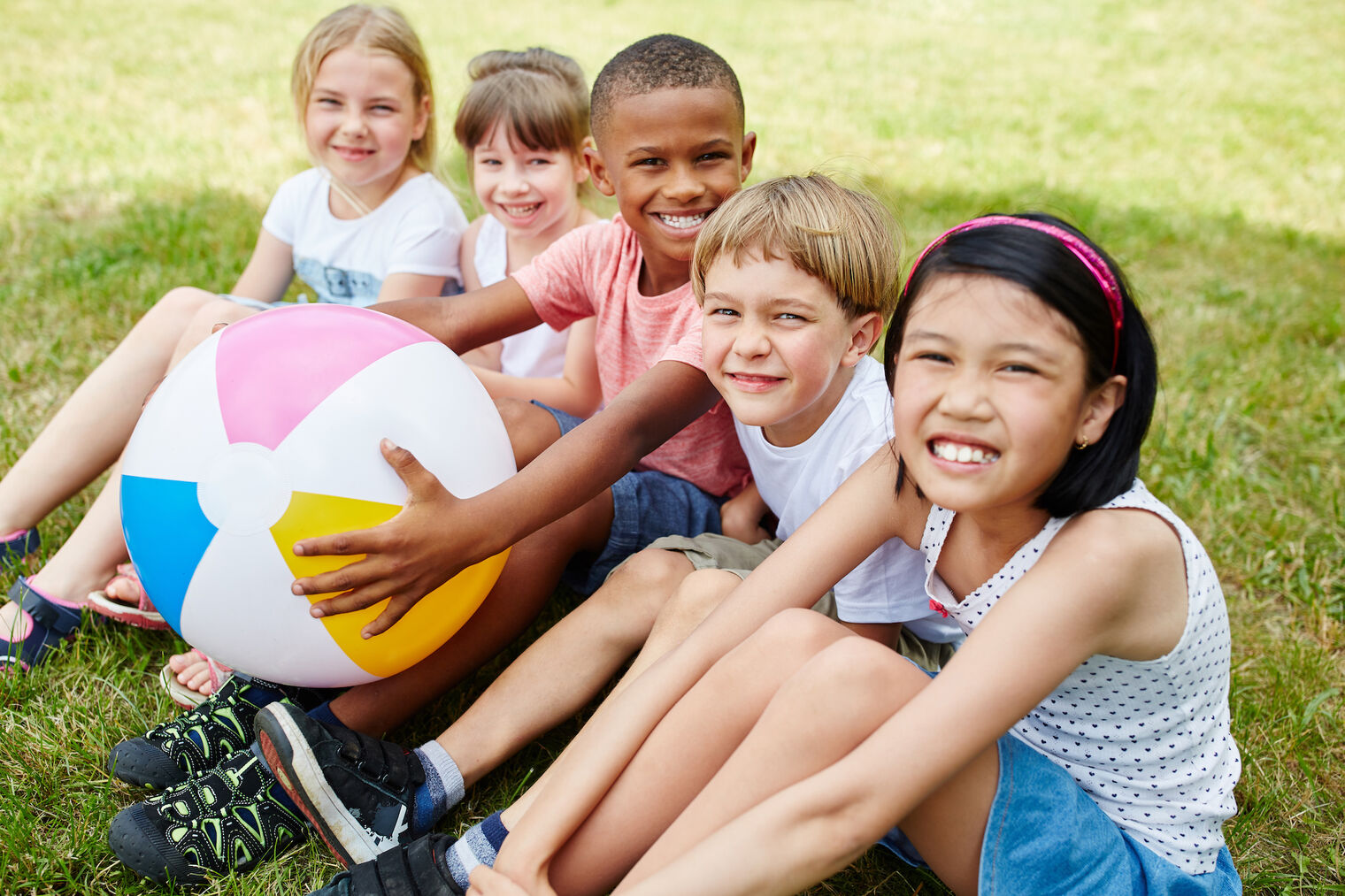 smiling kids sitting on grass